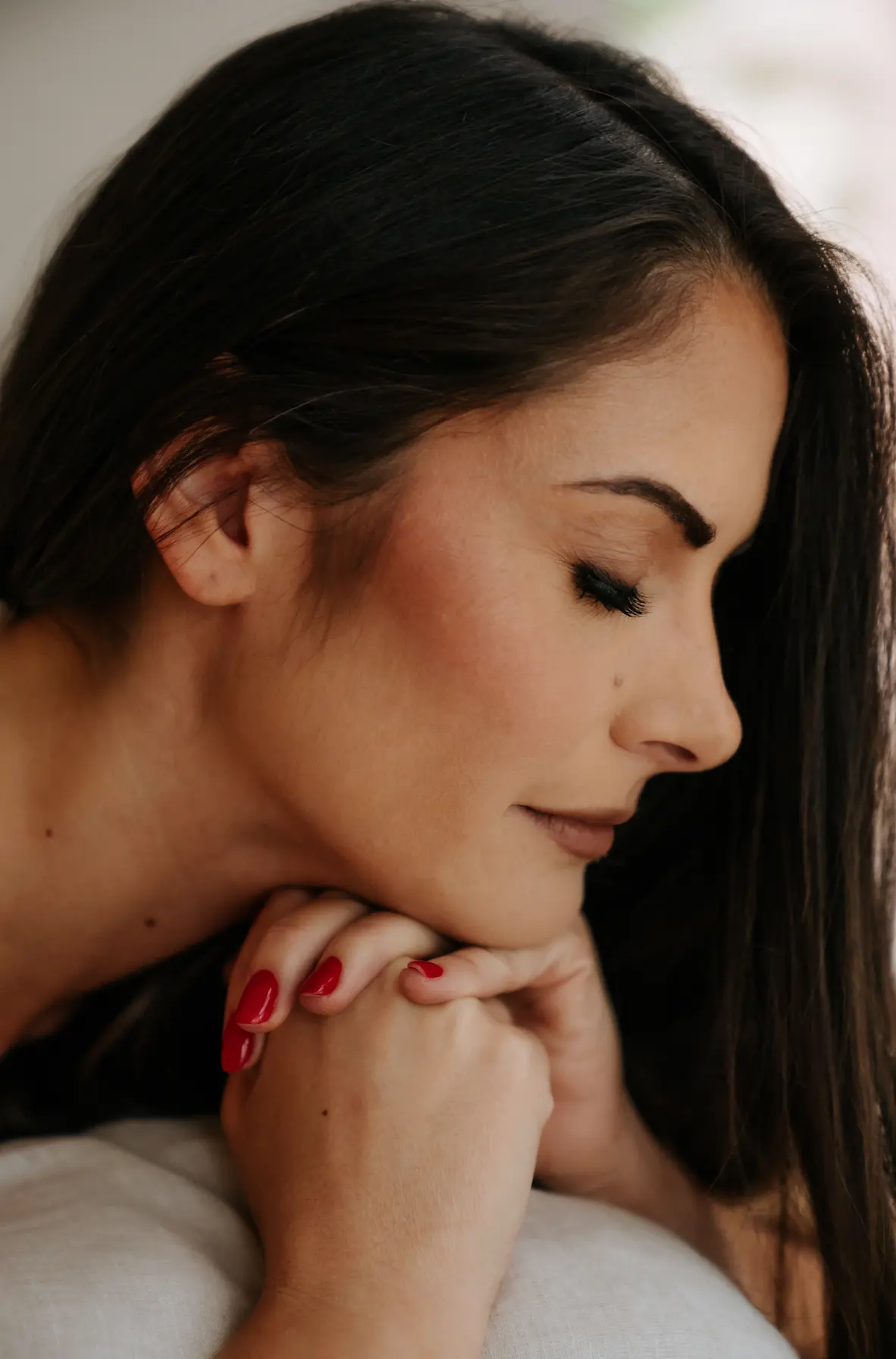Fay with closed eyes, resting her chin on her hands
