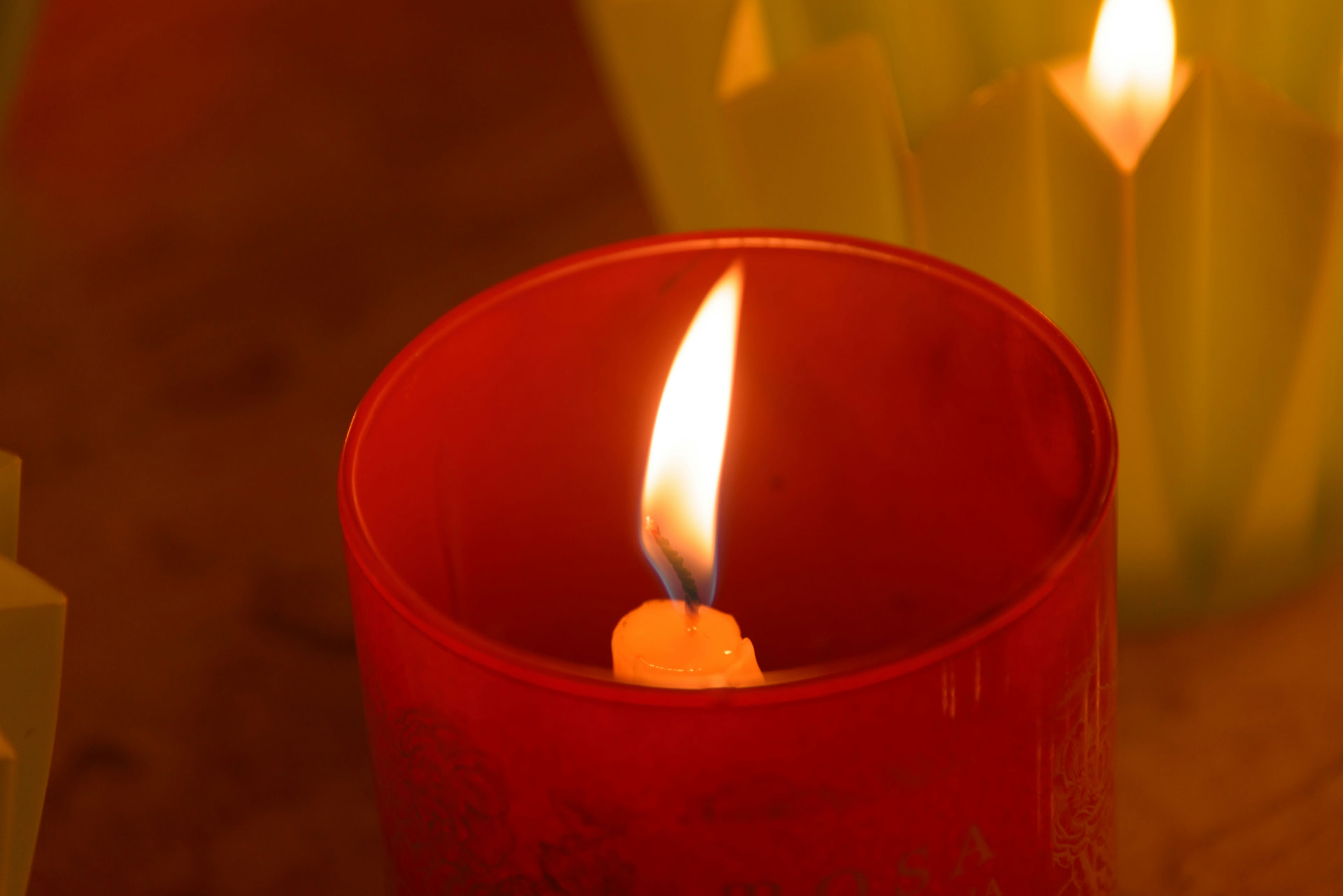 A red candle burning in warm evening light